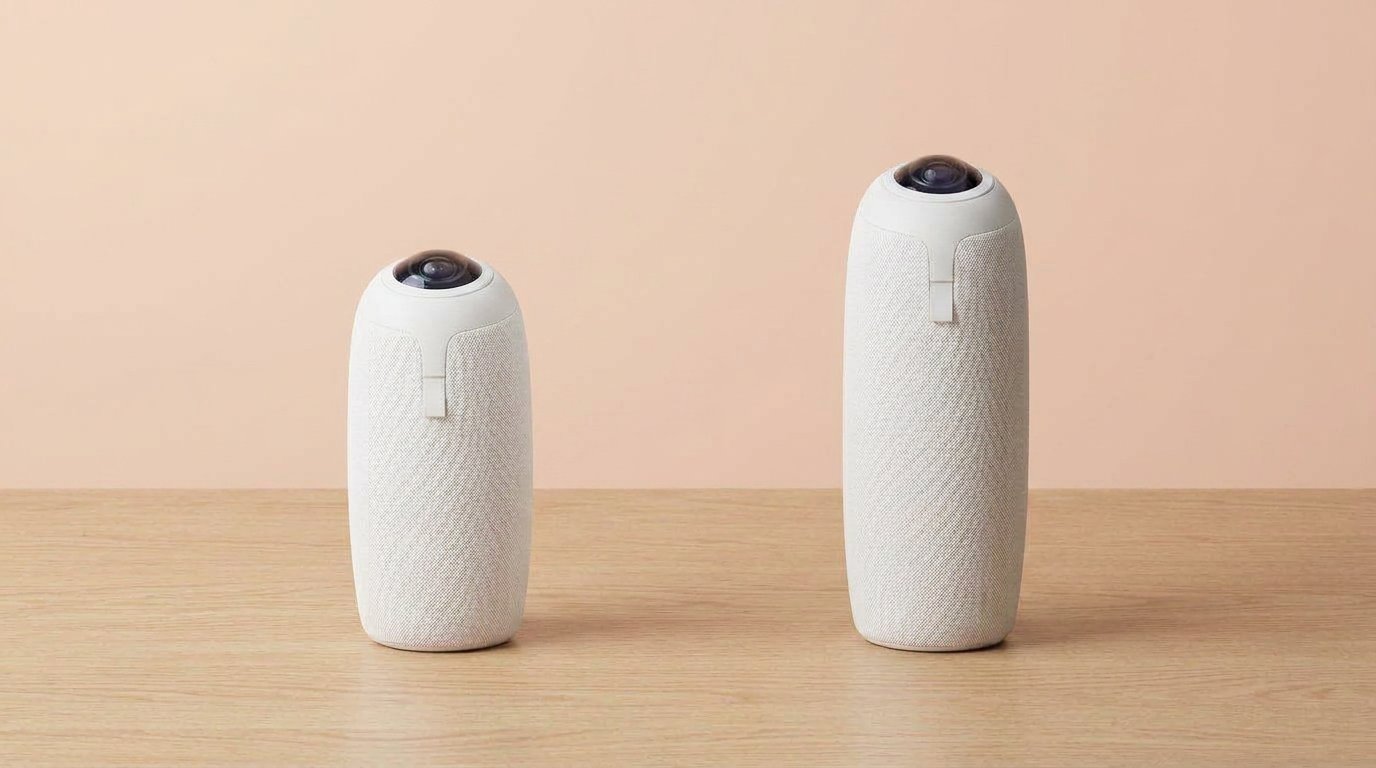 Two 360 meeting cameras side by side on a light desk