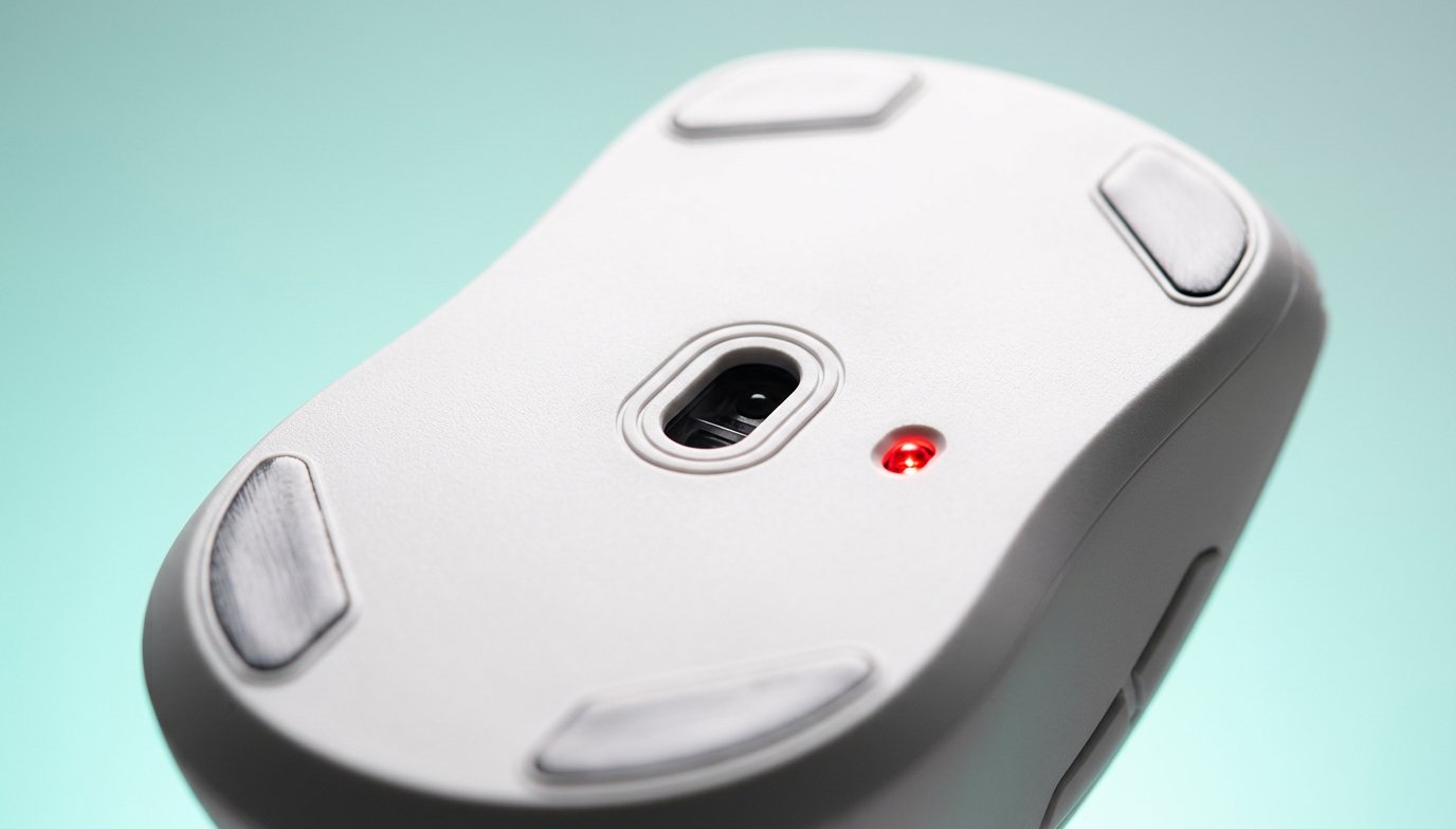 Close-up of a computer mouse optical sensor on a light teal background